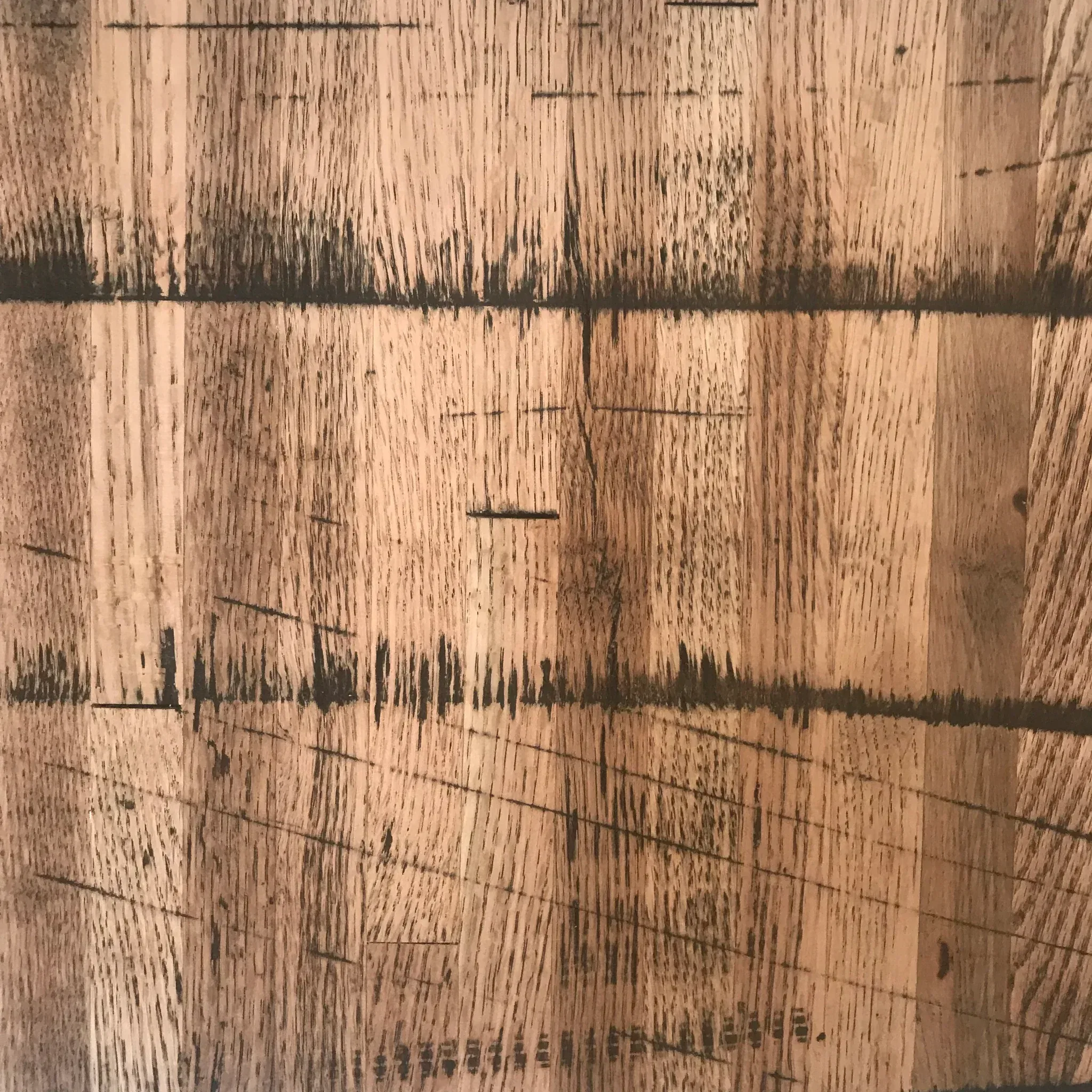 Close-up of a Reclaimed Rail Car Plank featuring a textured wooden surface with visible grain, horizontal black lines, and scratches, offering a rustic and weathered appearance.