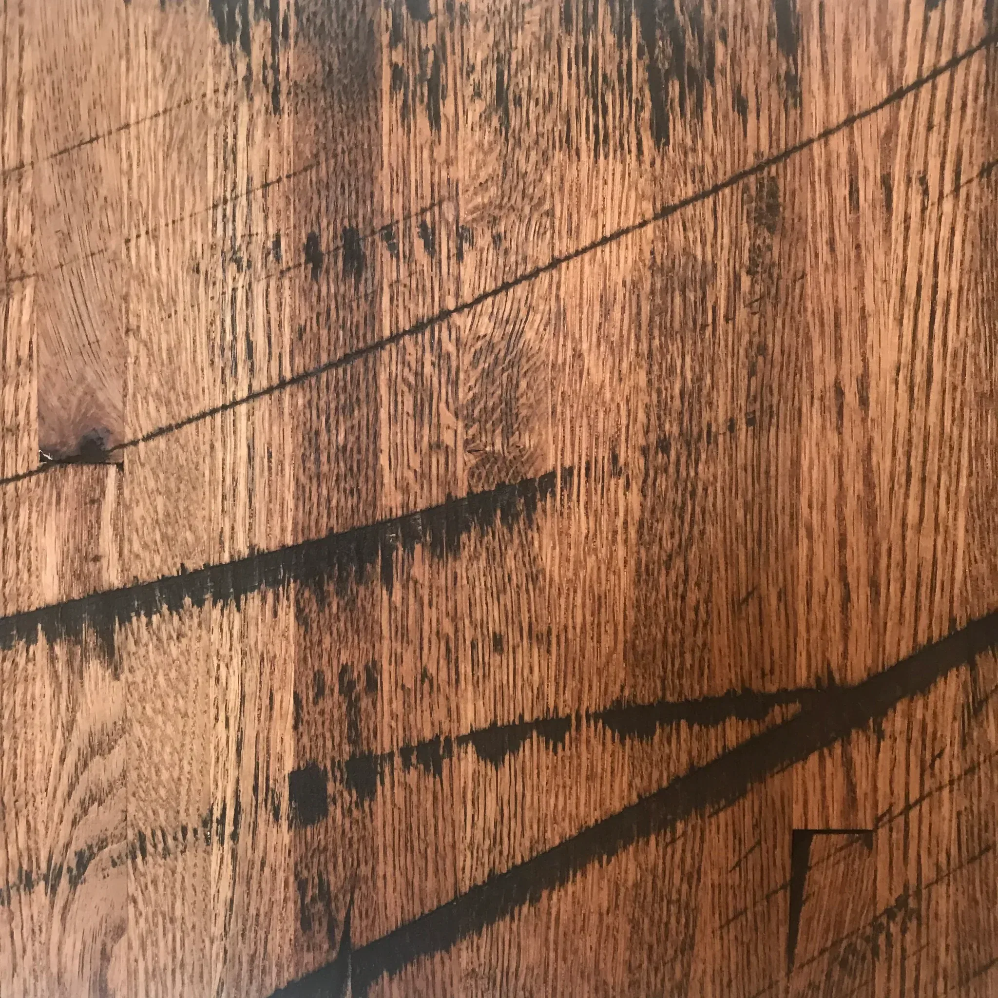 Close-up of a Reclaimed Rail Car Plank surface featuring a warm, rich brown hue with natural grain patterns, dark textured lines, and knots that provide a rustic and organic look.