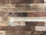 A close-up image of a wooden surface composed of various rectangular wooden planks in different shades of brown and beige. The wood has a rustic appearance with visible grain patterns and natural textures.